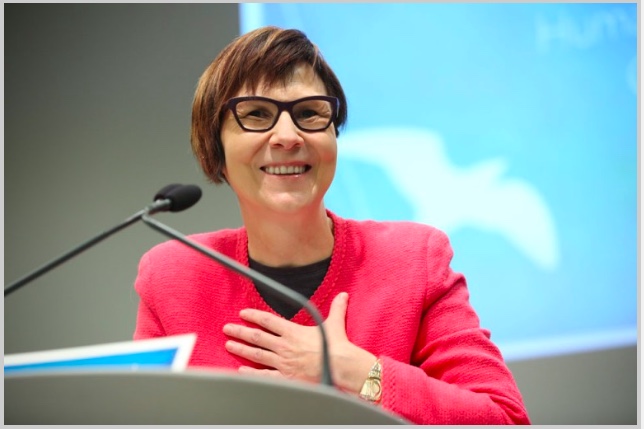 Photo of Dr. Cindy Blackstock delivering speech after receiving the Law Society's Human Rights Award in March 2017. She is at a podium with a microphone. She is smiling and her hand is on her chest.